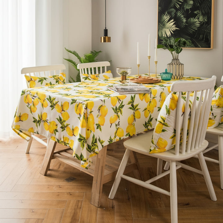 Dining room with a table covered by a lemon-patterned tablecloth.