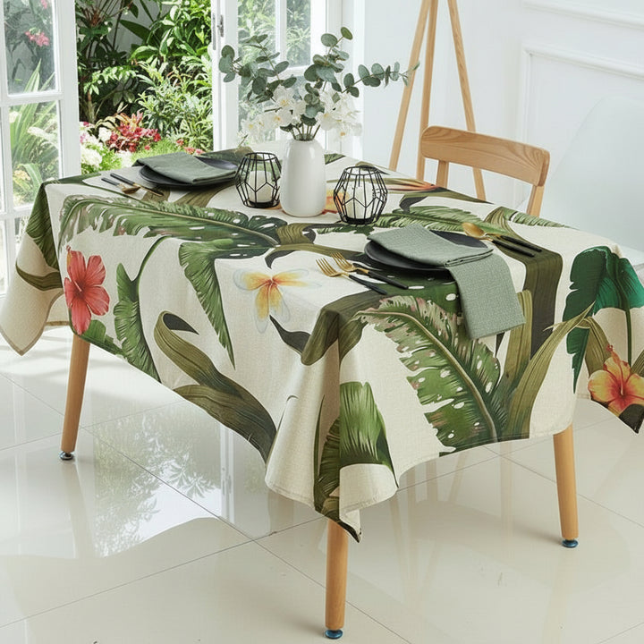 Tablecloth with tropical leaf and flower design on a dining table.