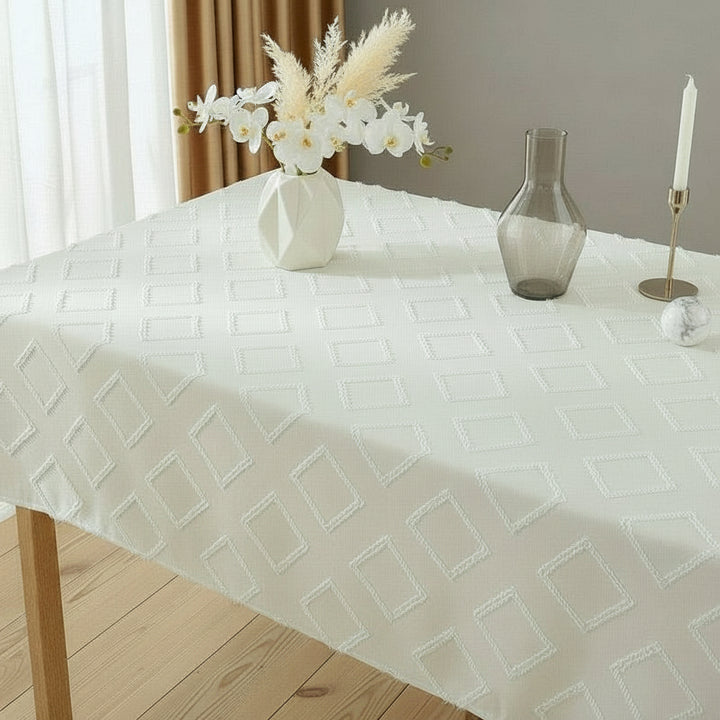 White linen blend textured tablecloth on a rectangular dining table with minimalist vases