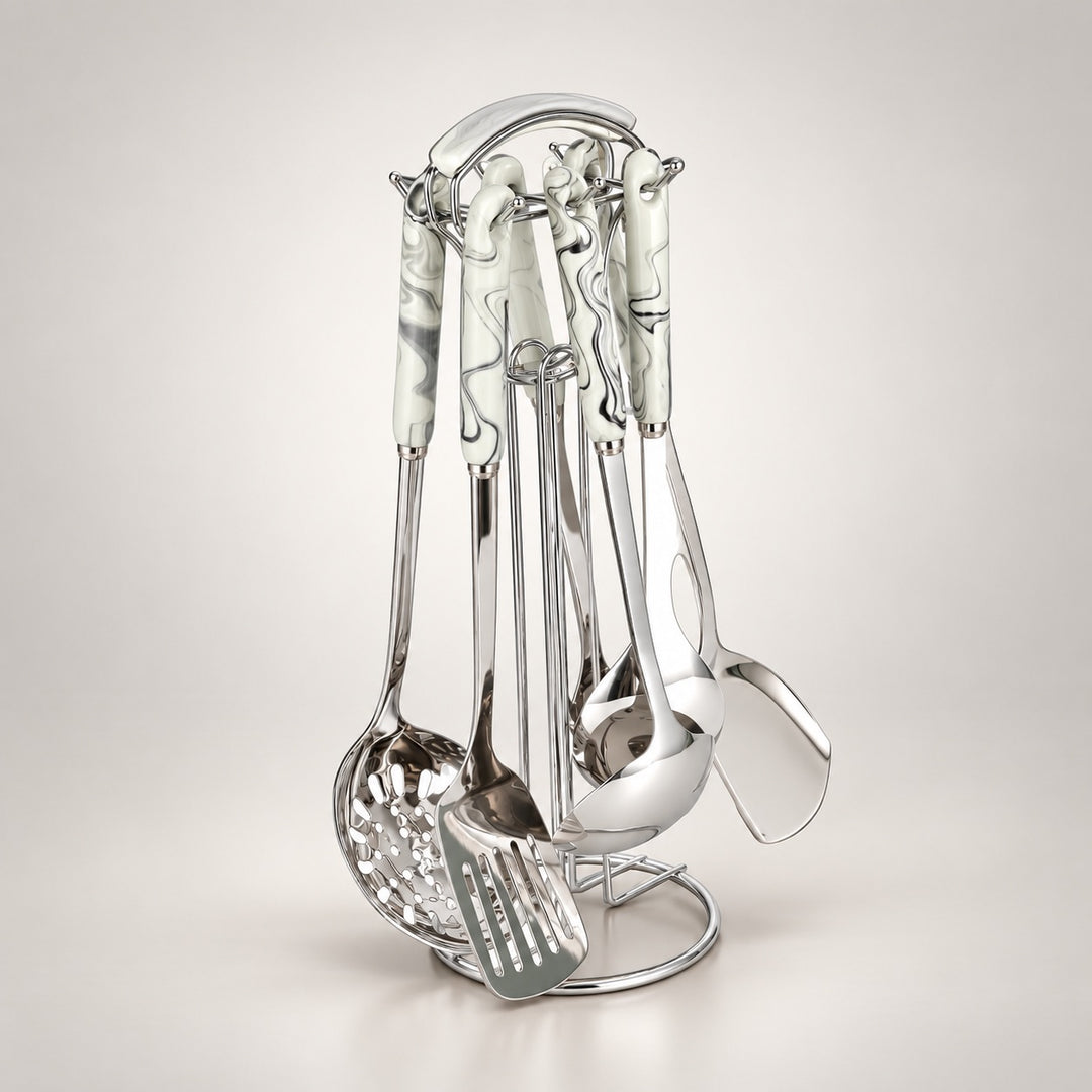 A stainless steel kitchen utensil set with white ceramic handles decorated with grey and black marble patterns, displayed on a matching metal stand against a light grey background.