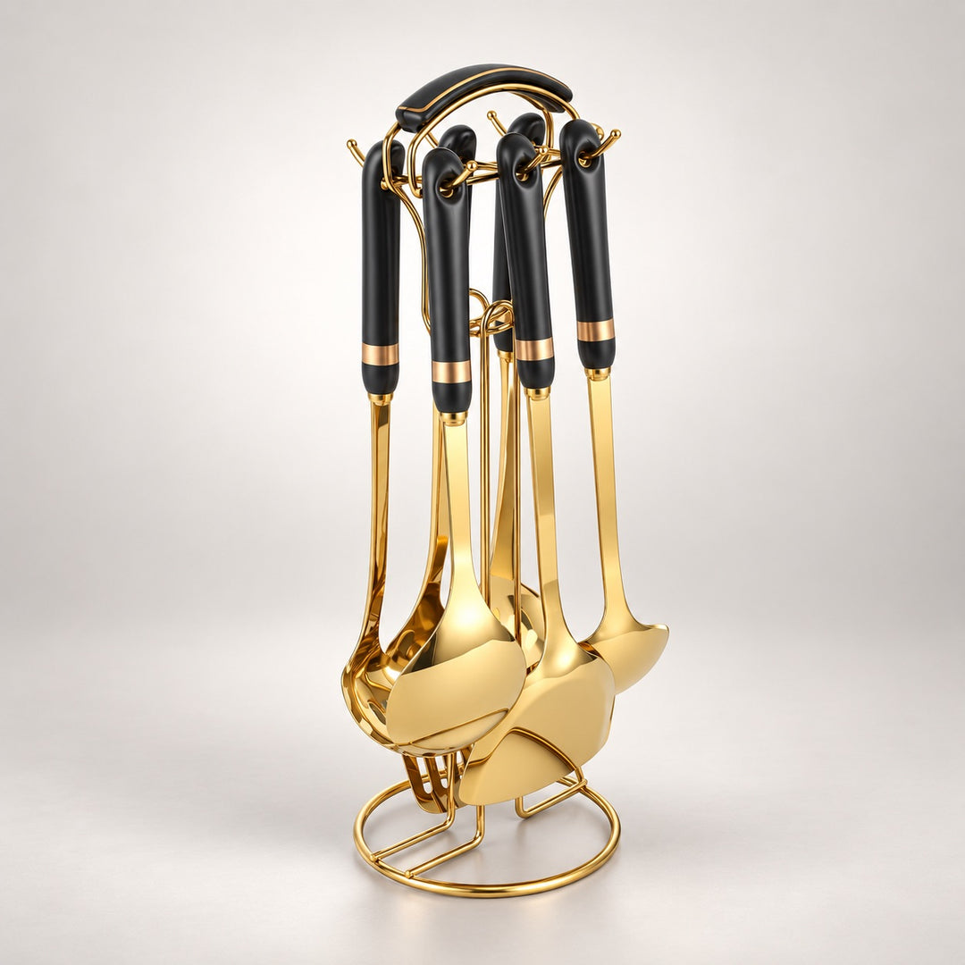 A set of six kitchen utensils with black handles and shiny gold metal bodies, displayed on a matching gold stand against a light gray studio background.