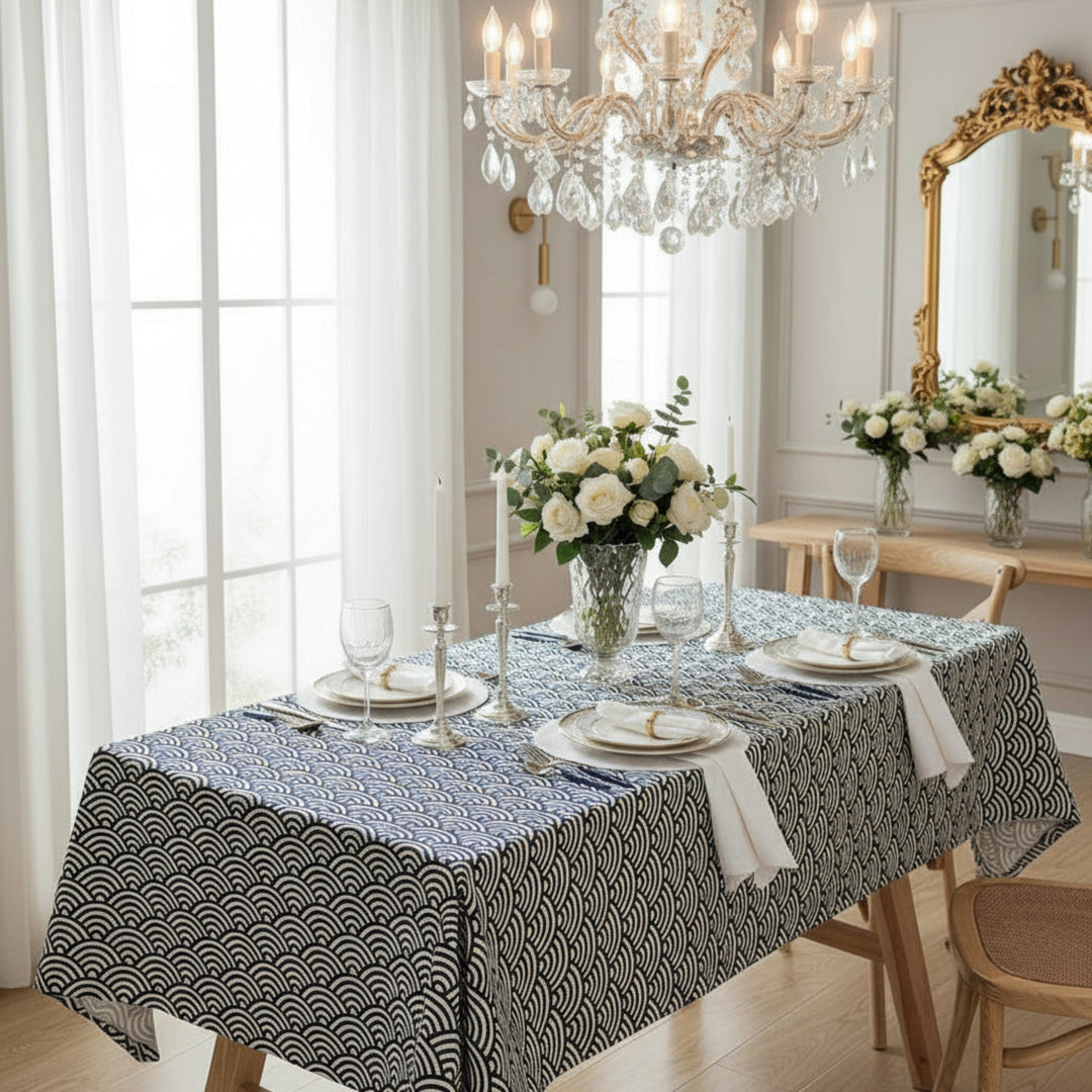 Dining room with a table set for a meal, featuring a chandelier and decorative mirror.
