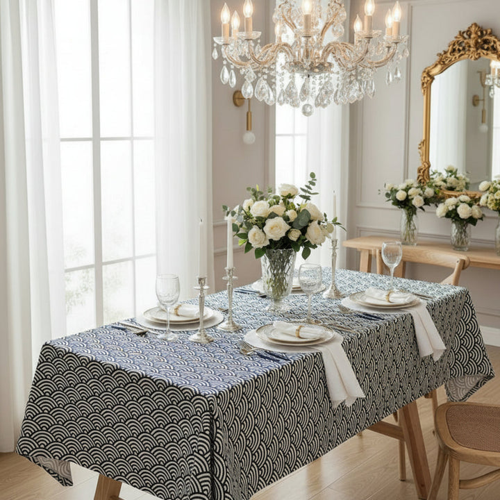 Dining room with a table set for a meal, featuring a chandelier and decorative mirror.