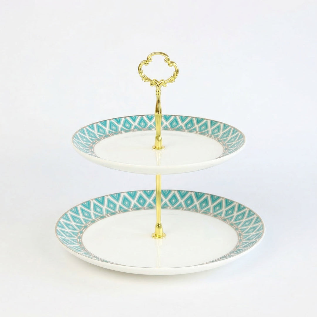 The Edwardian two-tiered bone china cake stand with gold accents on a white background