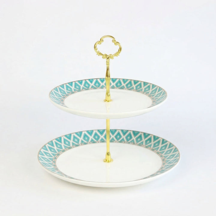The Edwardian two-tiered bone china cake stand with gold accents on a white background
