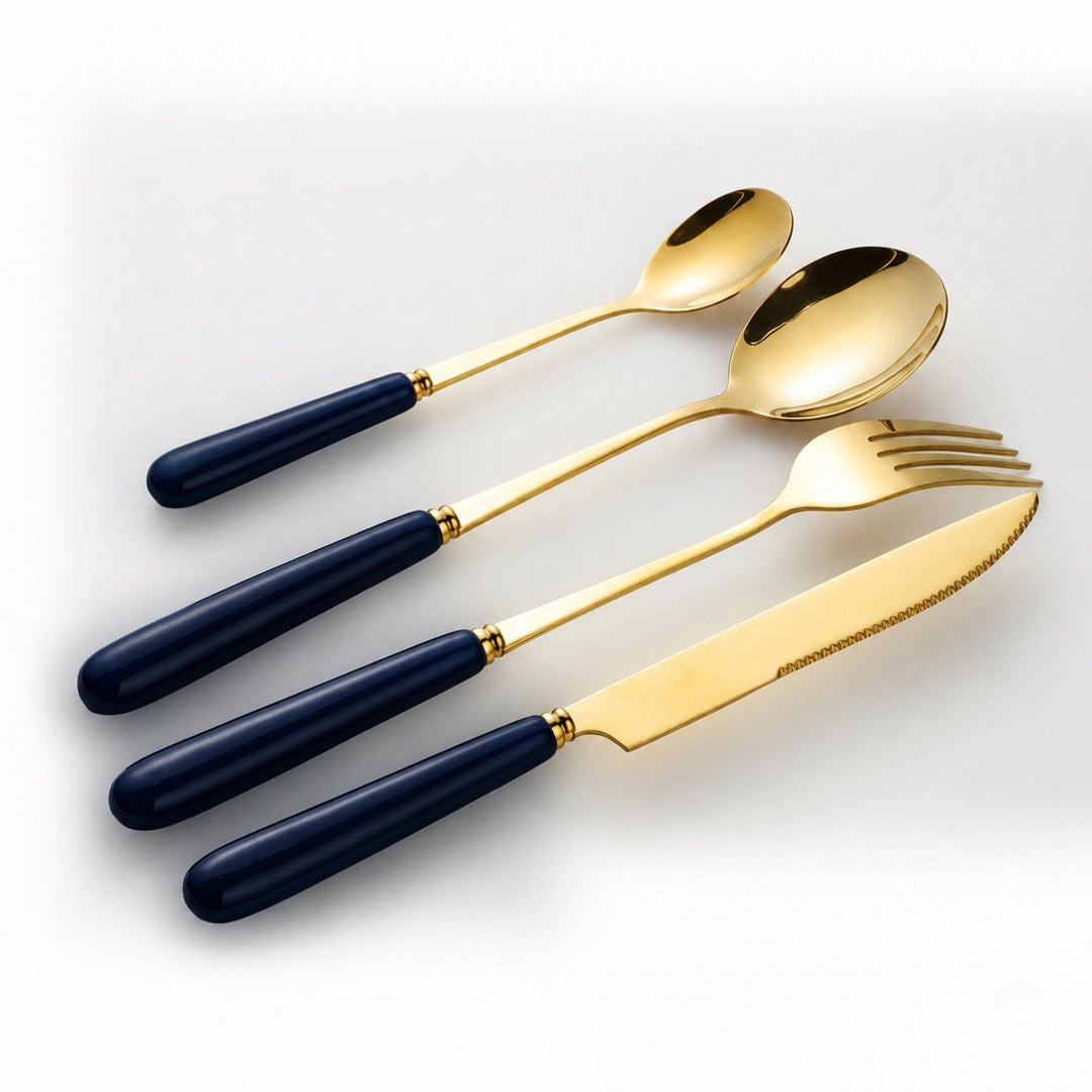 Angled view of Aldermere gold cutlery with glossy Midnight Navy ceramic handles