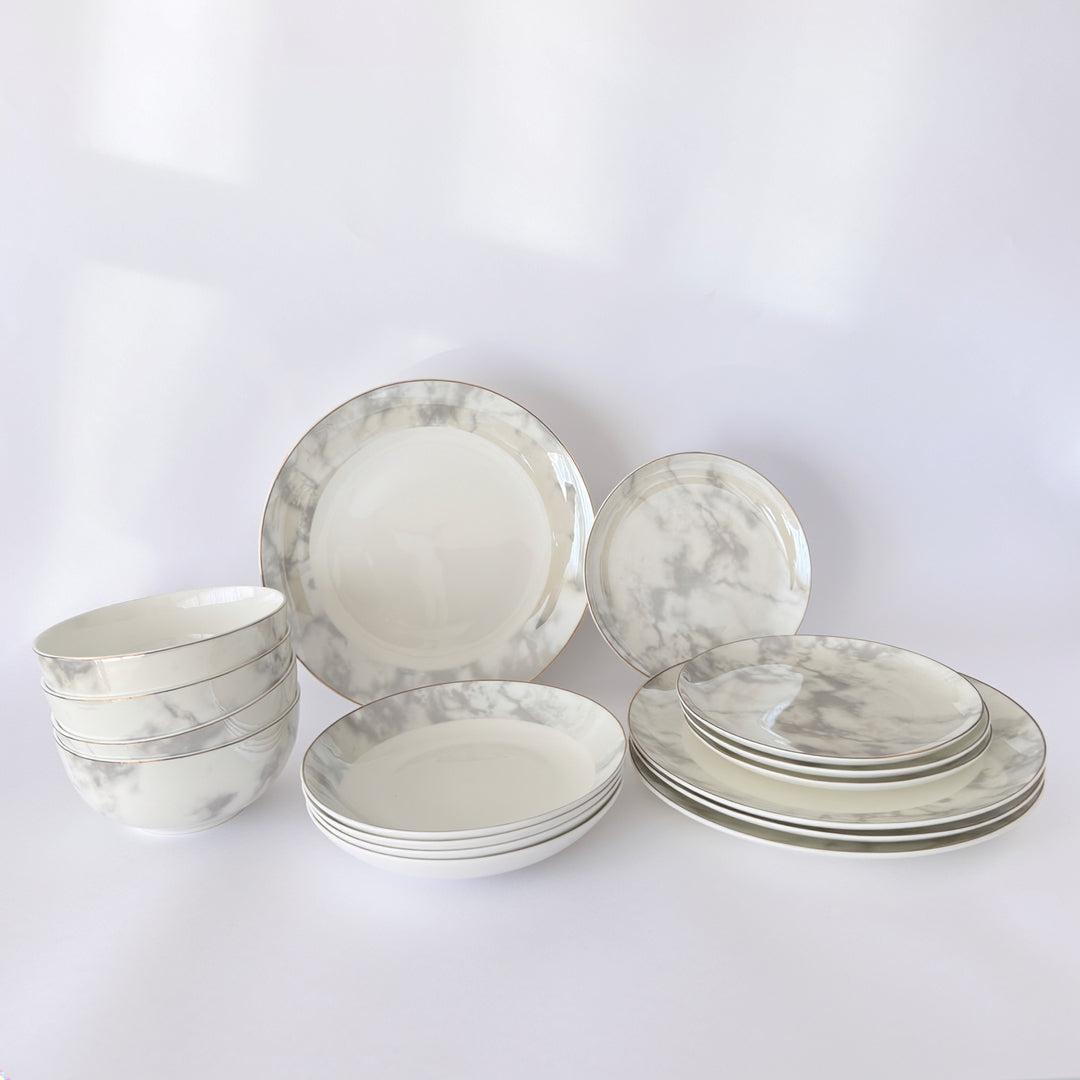 Stacked Aurelia fine bone china dinner set showing plates and bowls with marble finish and gold rim