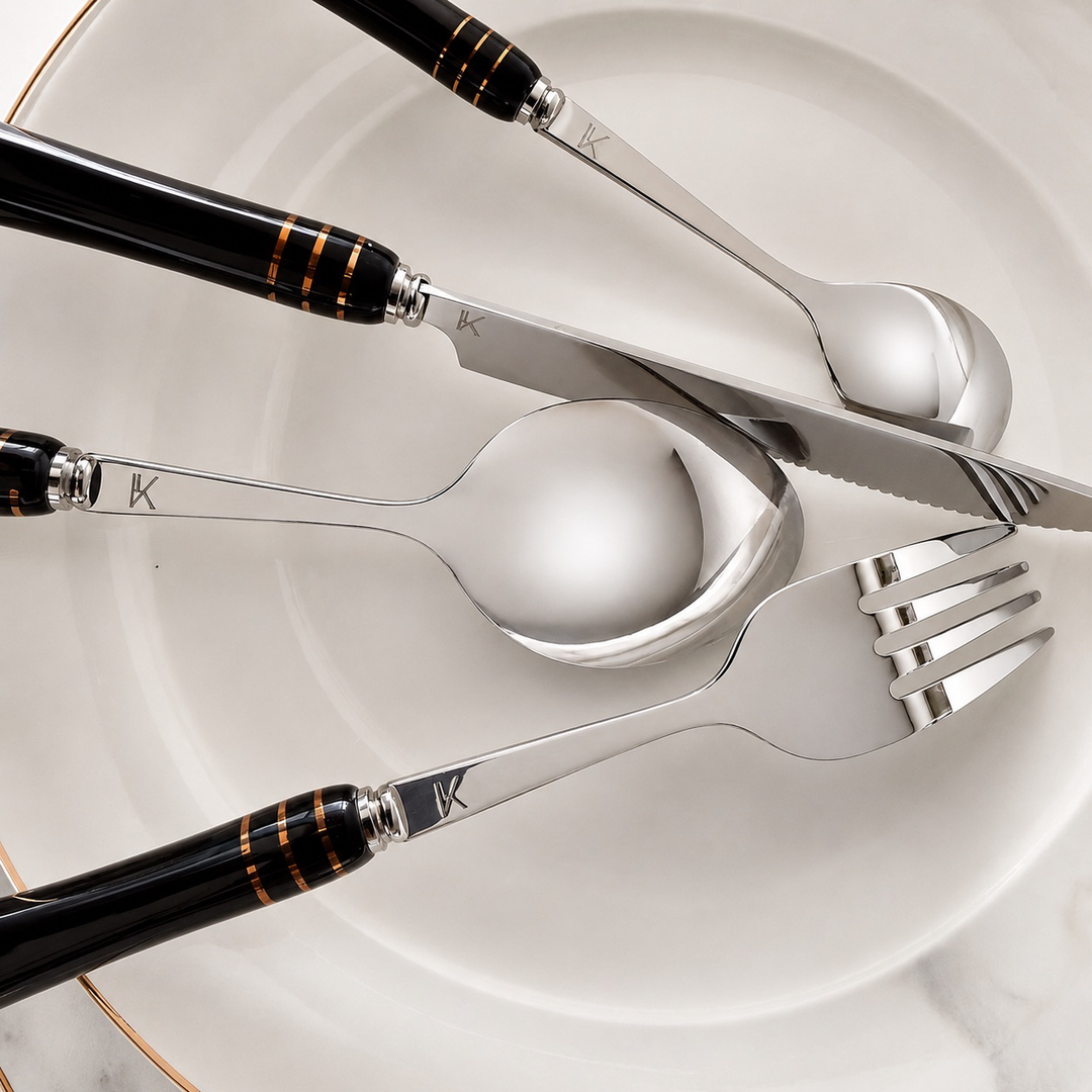 Close-up of Heritage Gold black ceramic-handle cutlery on neutral dinnerware