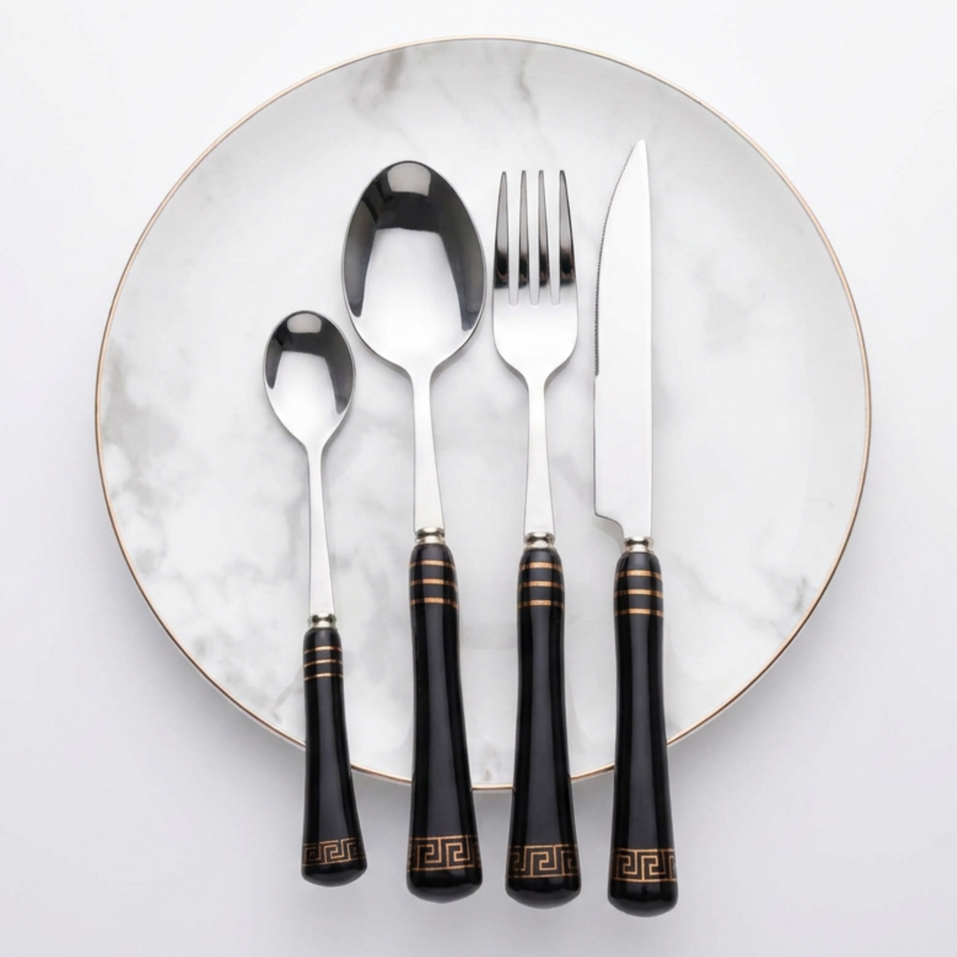 Heritage Gold black and silver four-piece cutlery setting on a marble-effect plate