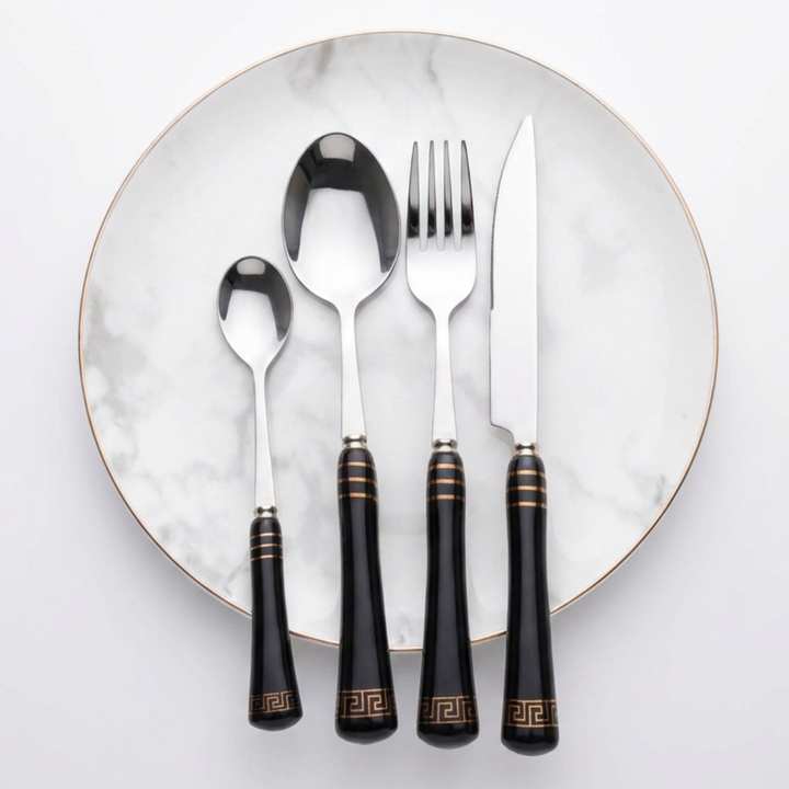 Heritage Gold black and silver four-piece cutlery setting on a marble-effect plate