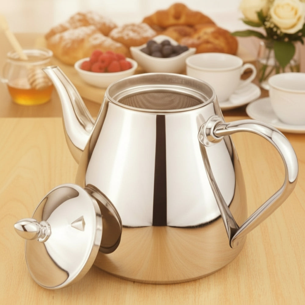 Silver teapot on a wooden table with breakfast items in the background