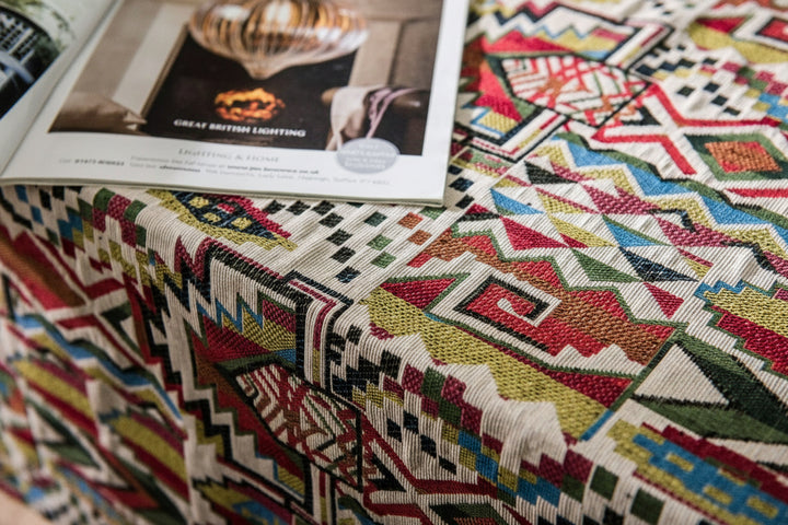 Colourful patterned fabric tablecloth with a magazine on top